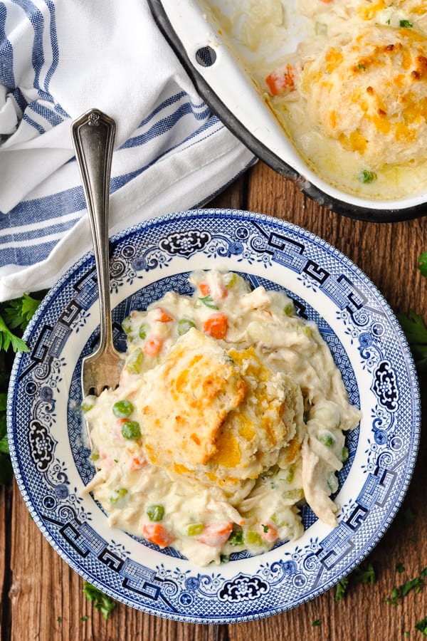 Close overhead shot of a serving of chicken and biscuits in a blue and white bowl