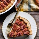 Overhead shot of a slice of pecan pie on a wooden table