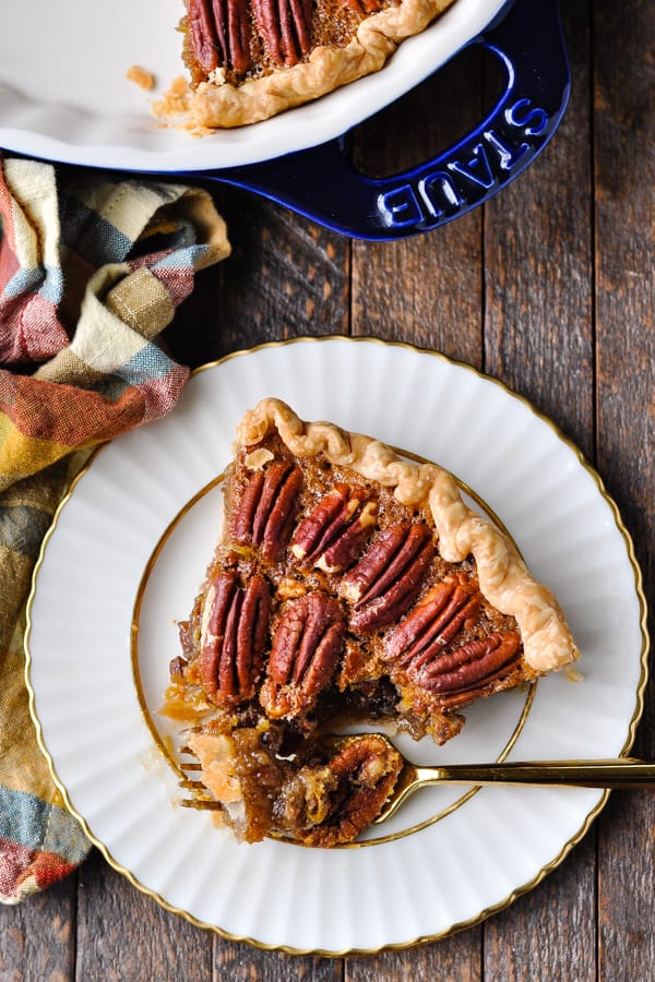 Overhead image of a slice of pecan pie with a fork taking a bite out of it