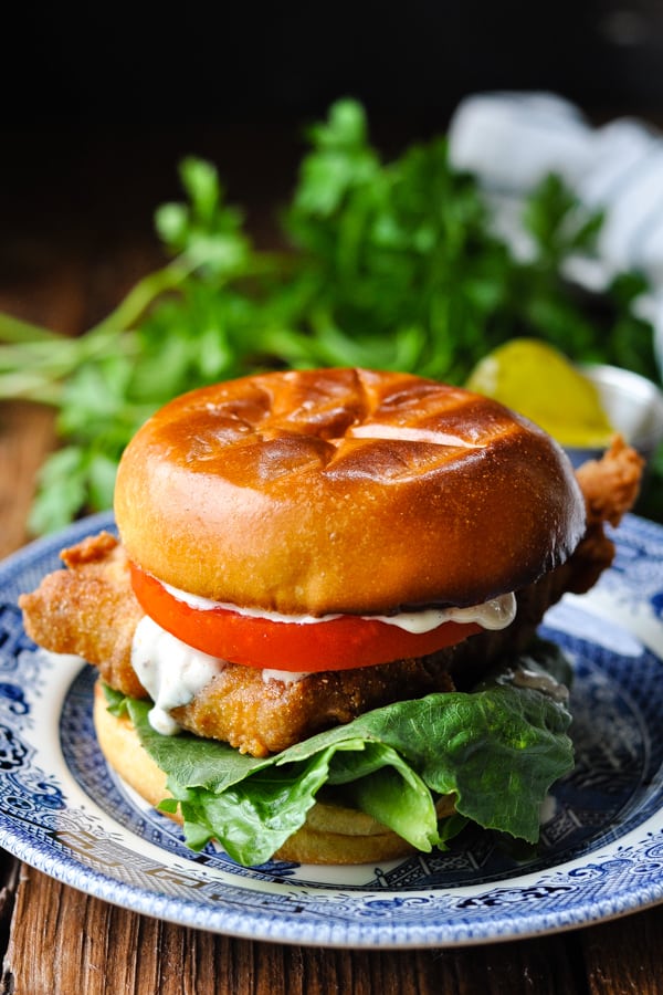 Front shot of a fried fish sandwich on a brioche bun with tartar sauce