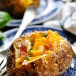 Baked potatoes with butter and other toppings on small serving plates