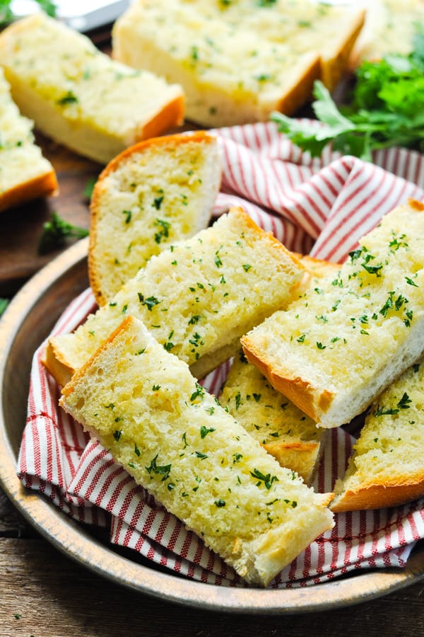 Front shot of homemade garlic bread in a dish on a wooden table