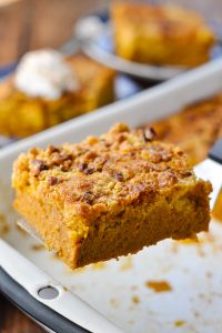 Close up shot of a slice of pumpkin dump cake on a spatula