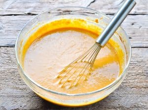Whisking together filling for pumpkin dump cake