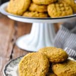 Front shot of homemade pumpkin cookies on a white plate in front of a dark background