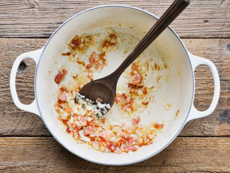 Adding onion to bacon in a Dutch oven.