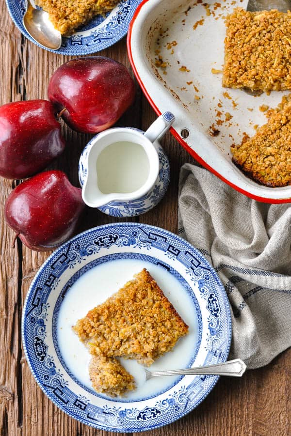 Overhead shot of easy baked oatmeal on a wooden table with fresh apples