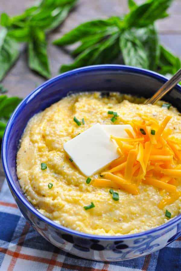 The best cheese grits recipe served in a blue bowl with fresh chives on top