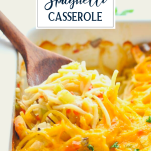 Side shot of a wooden spoon serving chicken spaghetti casserole recipe with text title overlay