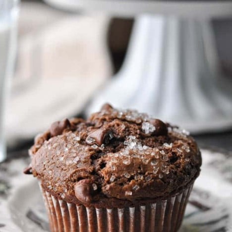 Close up side shot of a bakery style chocolate muffin on a plate