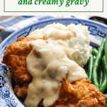 Front shot of fried chicken cutlets and gravy with text title box at the top