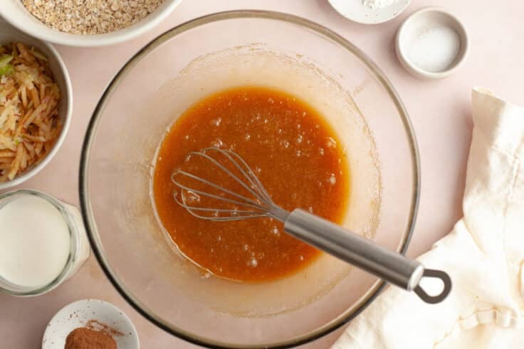 Whisking the wet ingredients for a baked apple oatmeal recipe.