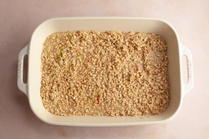 Spreading the oatmeal mixture in a white baking dish.