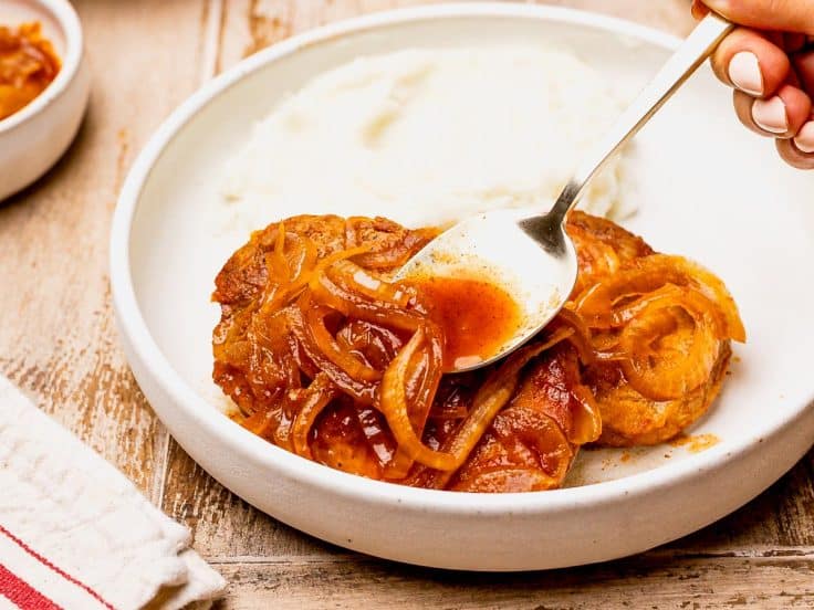 Spooning the onion gravy over Crock Pot pork chops.