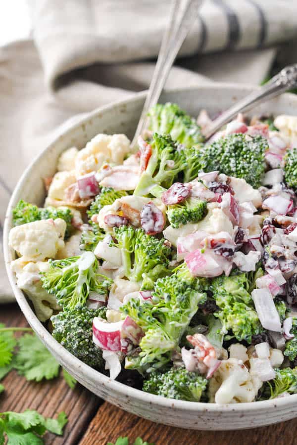Close up side shot of a big serving bowl full of the best broccoli cauliflower salad recipe