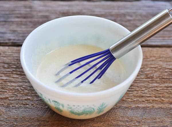 Whisking together a simple homemade mayonnaise and sour cream dressing