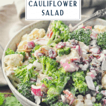 Side shot of a bowl of broccoli cauliflower salad recipe with a text title box at the top