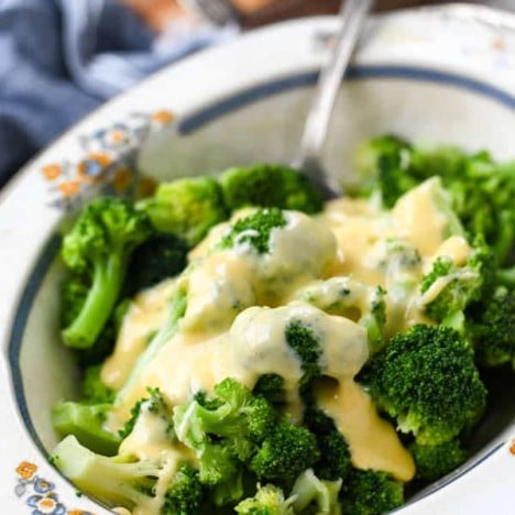 Close up side shot of broccoli and velveeta cheese sauce in a bowl