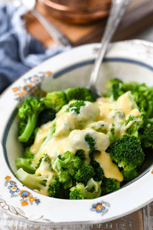 Close up side shot of broccoli and velveeta cheese sauce in a bowl
