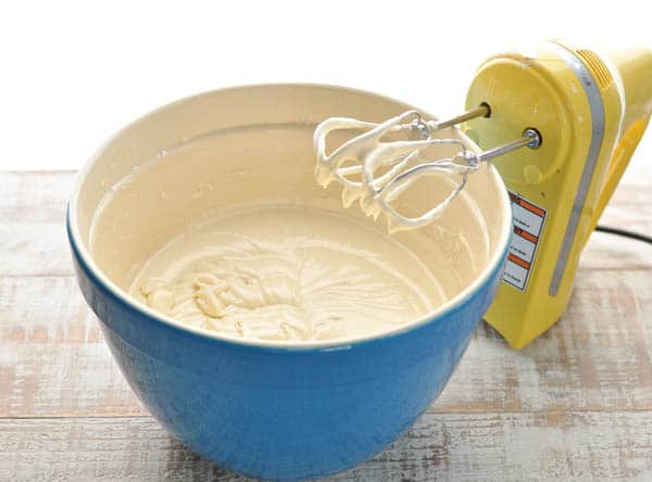 Vanilla cake batter in a blue mixing bowl