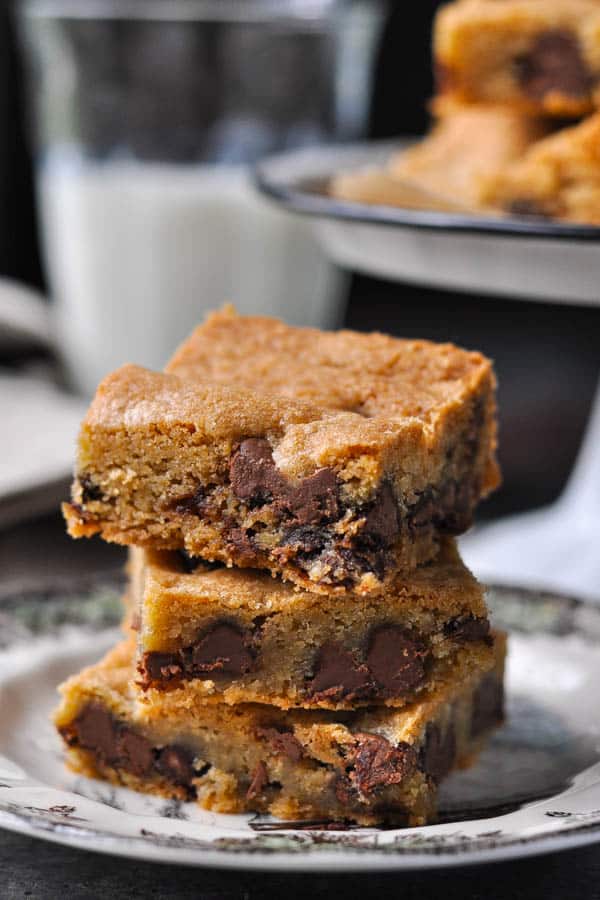 Stack of three chewy chocolate chip cookie bars on a plate