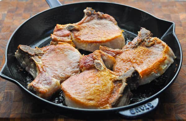 Pan fried thick pork chops in a cast iron skillet