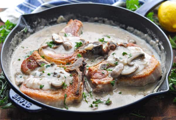Horizontal shot of a skillet full of smothered pork chops with cream of mushroom soup