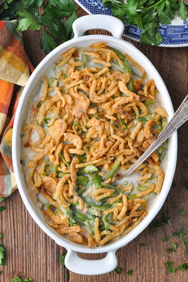 Long overhead shot of easy green bean casserole recipe in a white dish on a wooden table