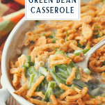 Front shot of a spoon in a dish of green bean casserole with a text title box at the top