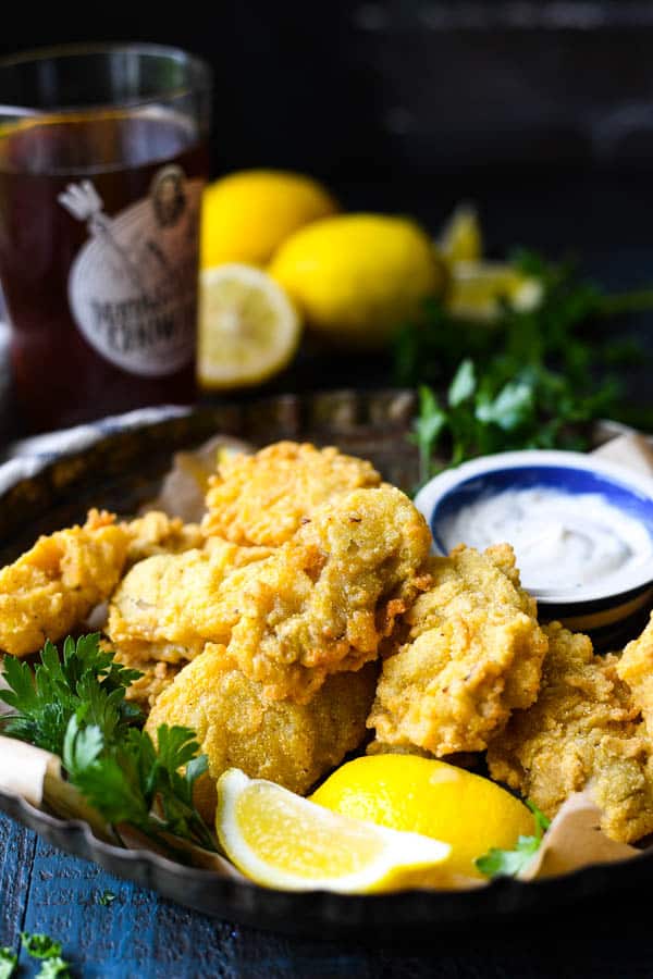 Front shot of deep fried oysters served with lemon wedges and dipping sauce