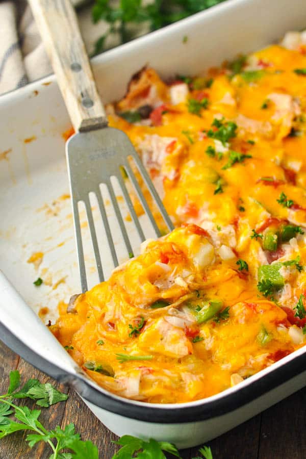 Spatula serving a slice of easy king ranch chicken from a casserole dish