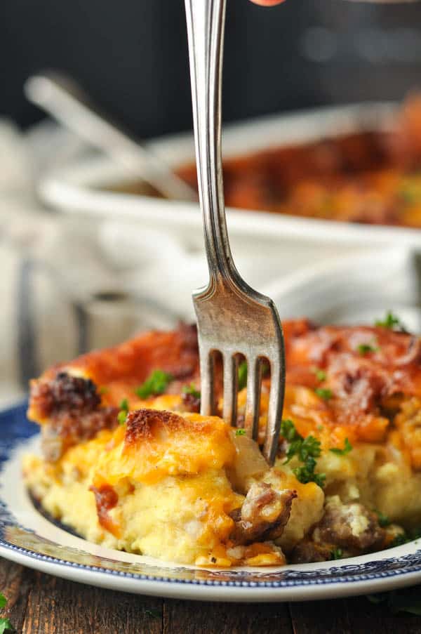 Fork digging into a slice of easy sausage breakfast casserole
