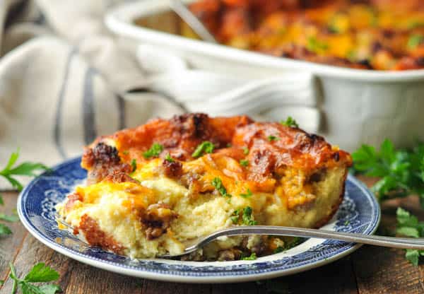 Horizontal shot of a slice of easy sausage breakfast casserole on a blue and white plate