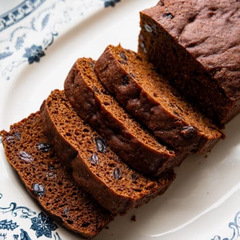 Square close up image of a sliced loaf of Boston brown bread.