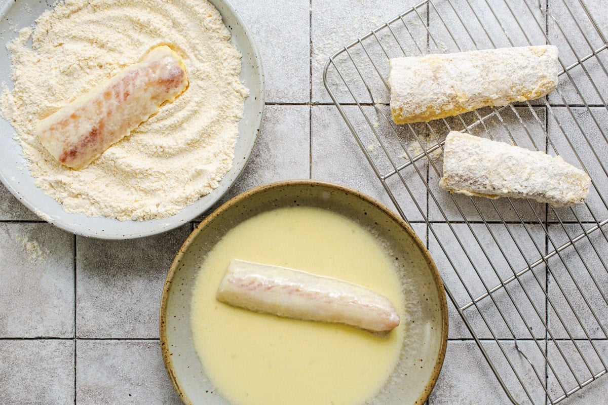 Process shot showing how to bread the fish before frying.
