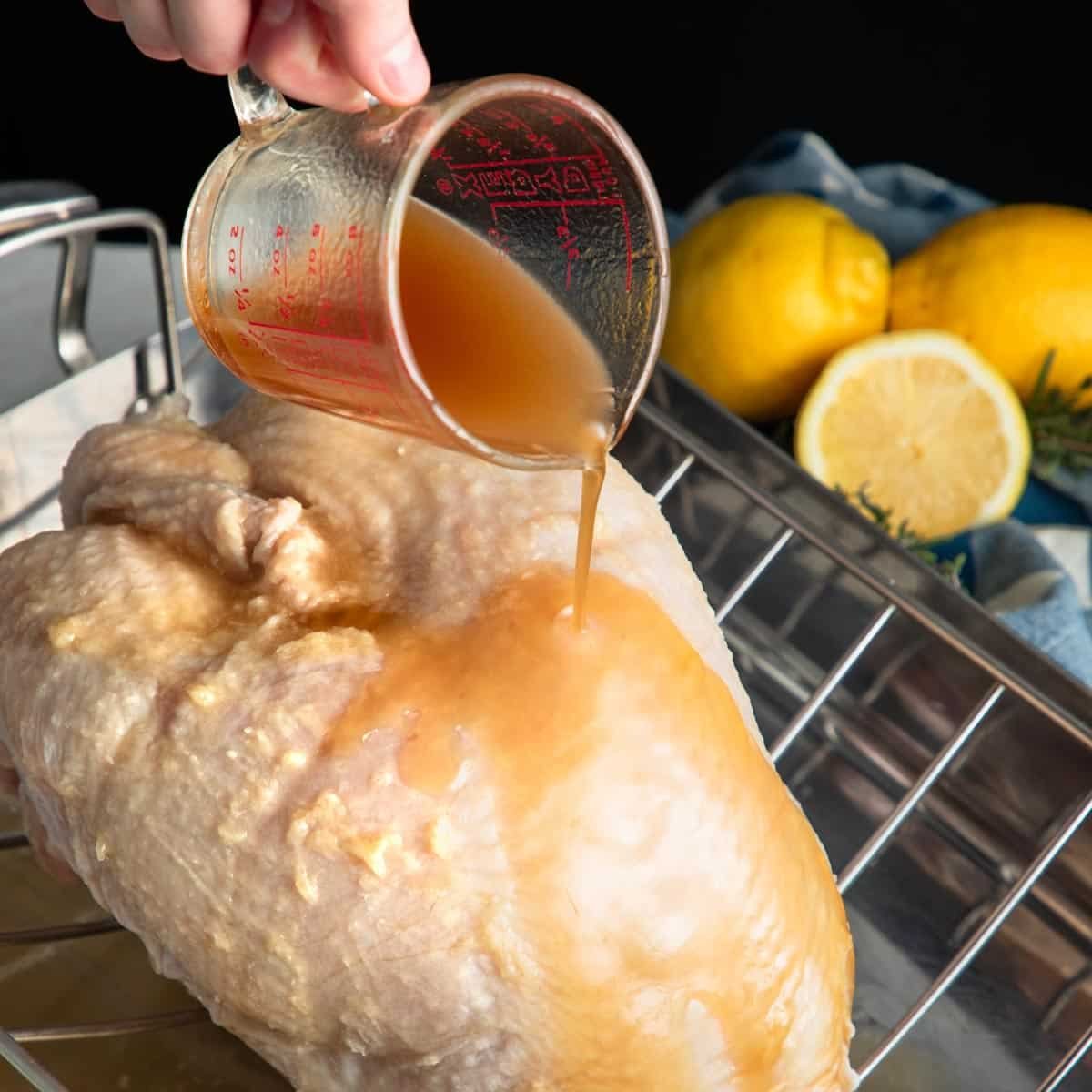 Pouring maple butter glaze on a whole turkey breast.