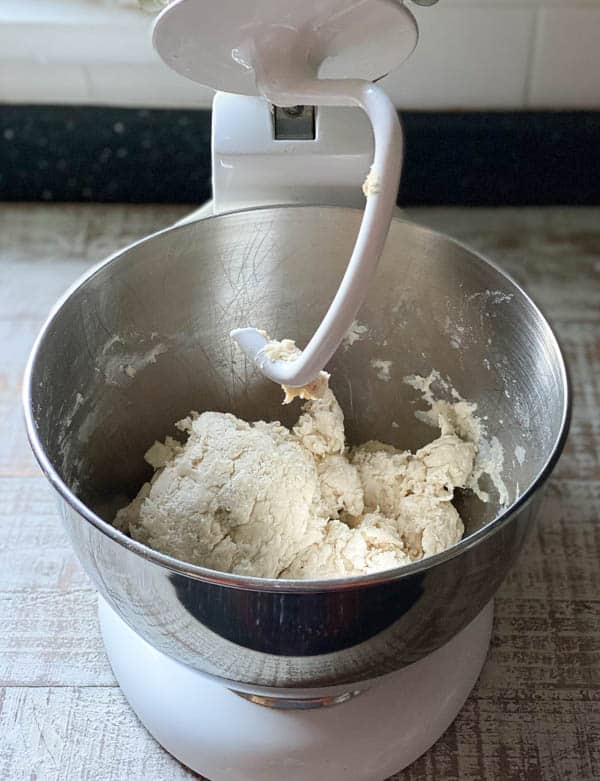 Baguette dough in a metal bowl of a stand mixer, after being mixed with the dough attachment.