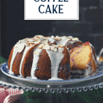 Front shot of a sour cream coffee cake on a cake stand with text overlay