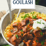Front shot of hungarian beef goulash in a bowl with text title overlay