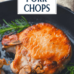Brined pork chops fried in a skillet with text title box at top