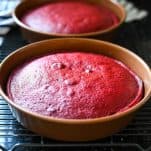 Easy red velvet cake recipe cooling in the pans on a wire rack