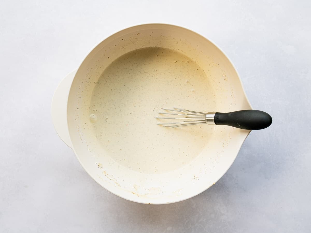 Whisking the Alabama white bbq sauce in a mixing bowl.