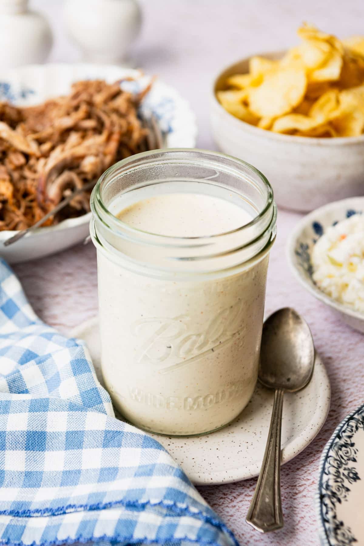 Side shot of Alabama white bbq sauce in a mason jar.