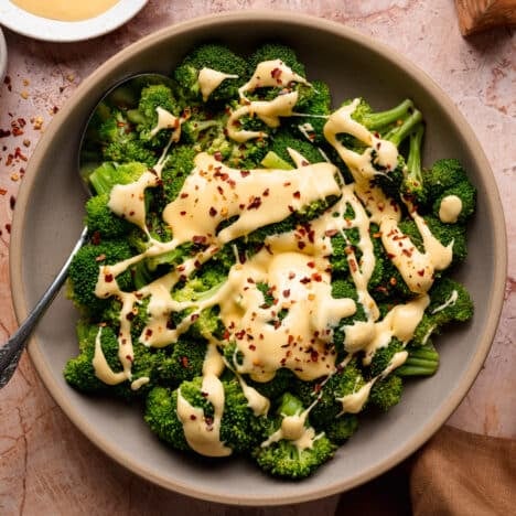 Square overhead shot of a bowl of broccoli and cheese.