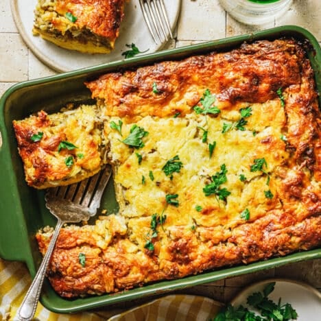 Square overhead shot of a sausage egg and cheese casserole in a green dish.