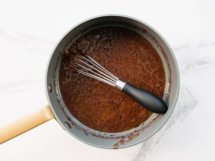 Whisking the icing for Texas sheet cake in a saucepan.
