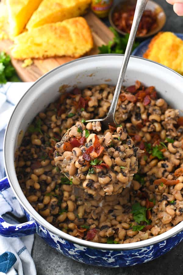 Ladling black eyed peas from a Dutch oven