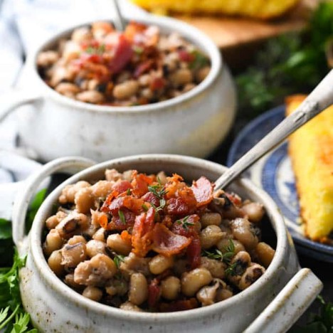 Two bowls of Southern black eyed peas recipe topped with bacon