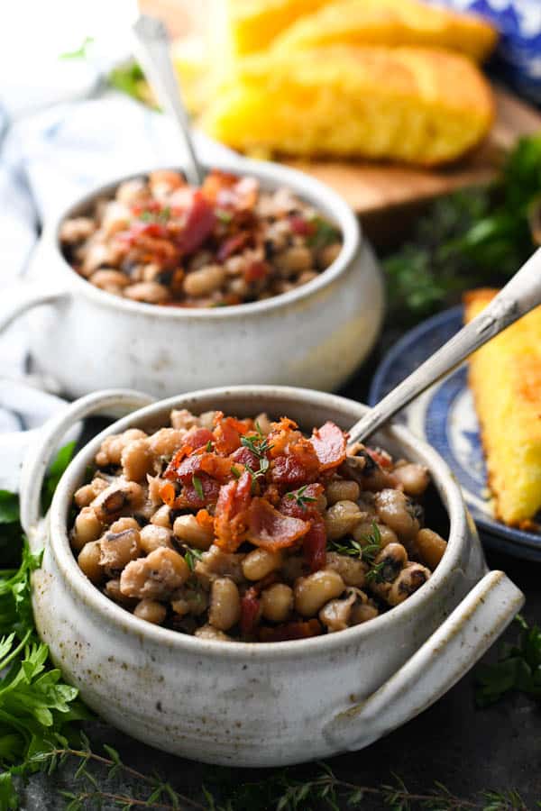 Two bowls of Southern black eyed peas recipe topped with bacon