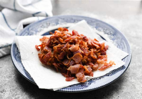 Crispy chopped bacon draining on a plate